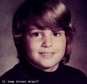 an old photo of a young boy with blonde hair and wearing a black t - shirt