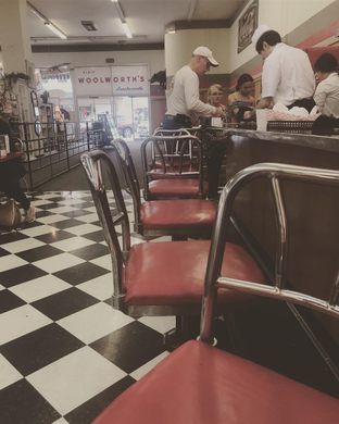 the diners are waiting for their order at the checkerboard floored restaurant