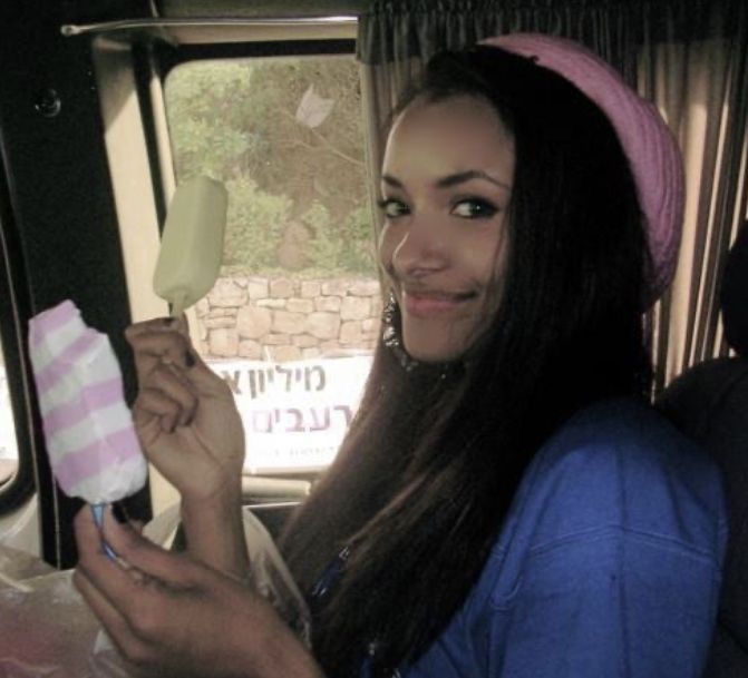 a woman sitting in the back seat of a car holding an ice cream popsicle