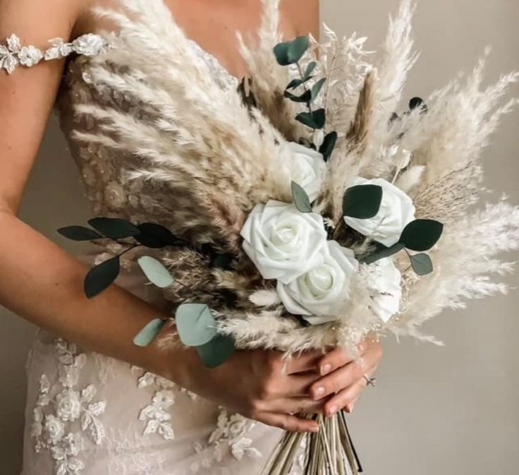 a woman holding a bouquet of flowers and feathers