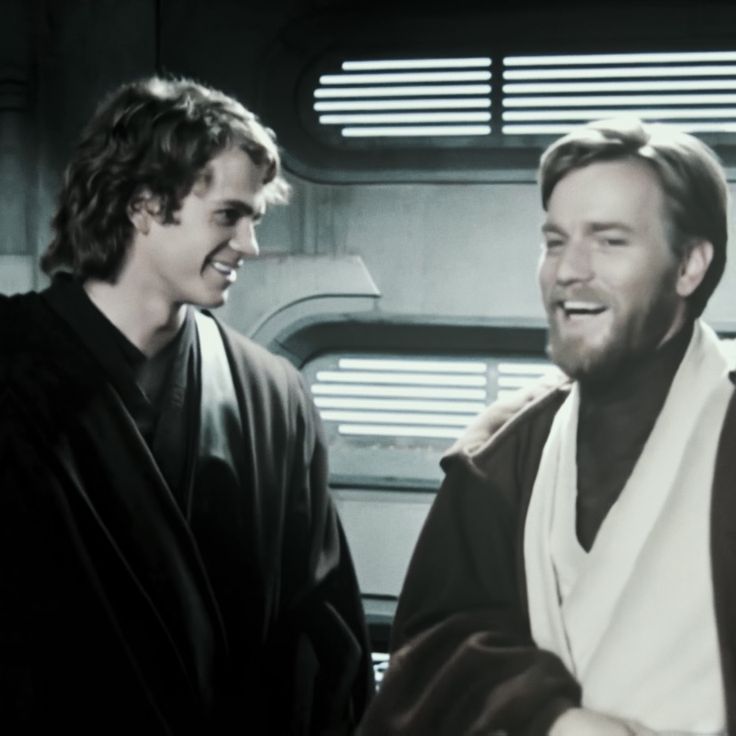 two men are talking in front of a star wars scene, one is wearing a robe and the other is smiling