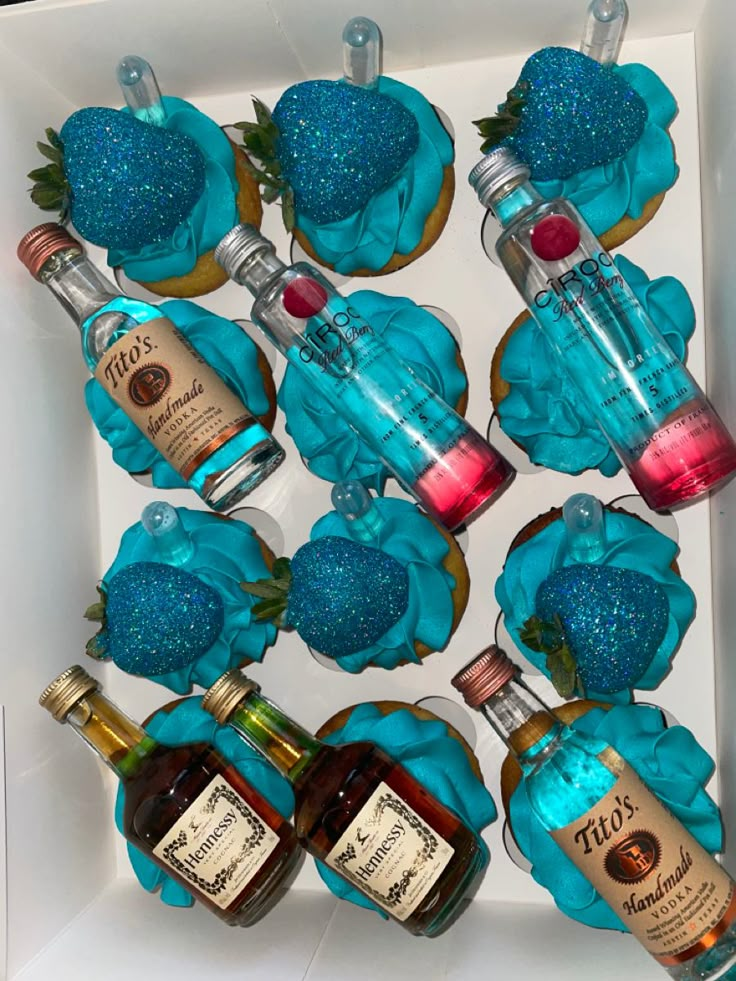 cupcakes with blue frosting and teal decorations in a box