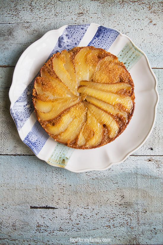 a pineapple upside down cake on a white plate with blue and white striped napkin