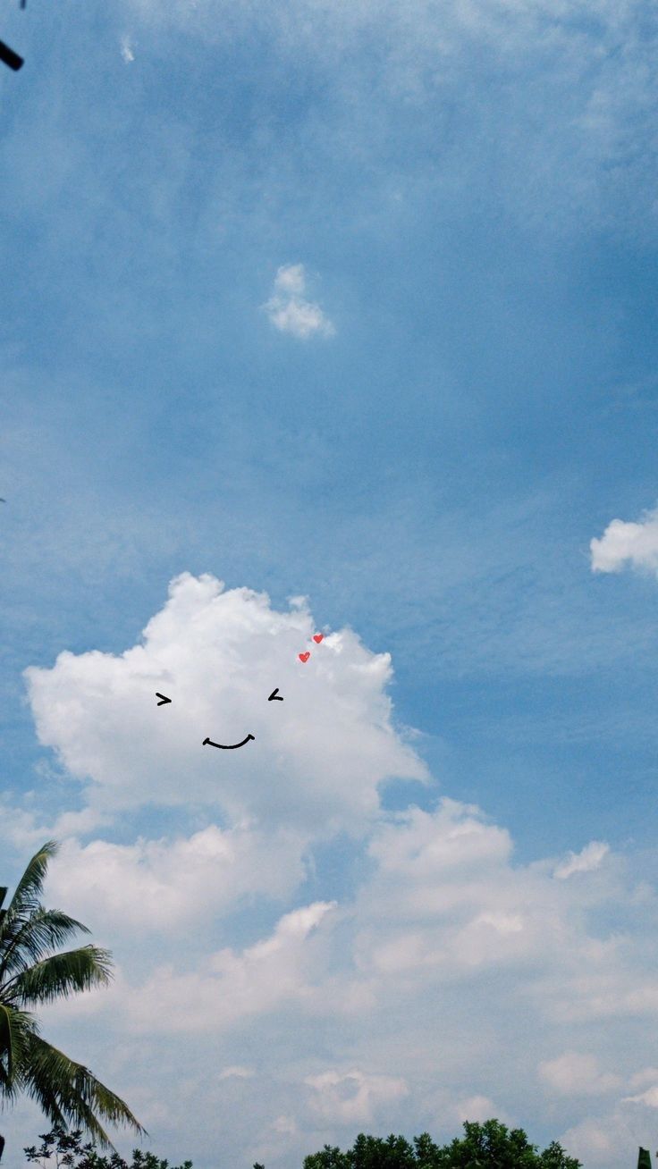 some birds flying in the sky with trees and clouds behind them on a sunny day