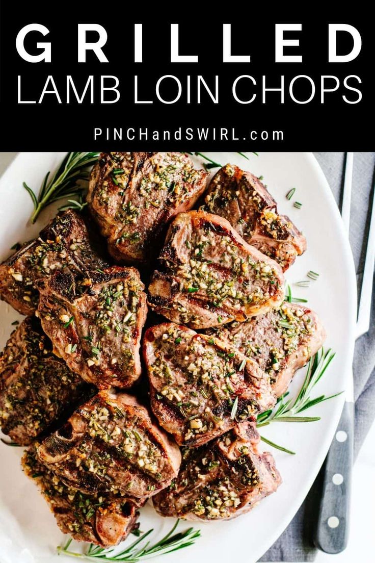 grilled lamb loin chops on a white plate with rosemary garnish