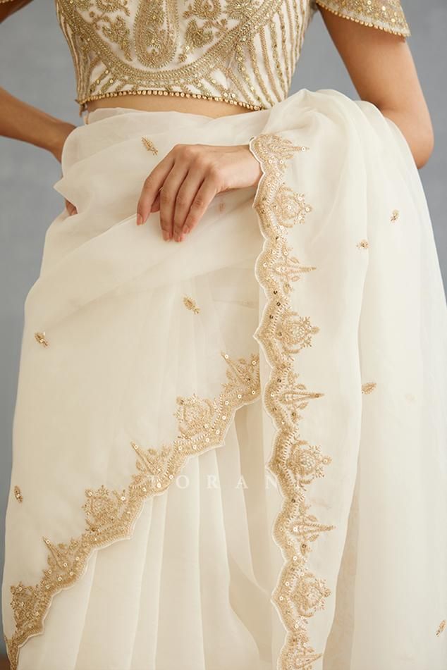 Ivory saree with dori, sequin embroidery in floral pattern and mughal border.
Components: 1
Pattern: Embroidery
Type Of Work: Dori, sequin, floral
Fabric: Silk Organza
Color: Ivory
Other Details: 
Mughal border
Cutwork hem
Note: Blouse worn by the model is not for sale
Occasion: Wedding - Aza Fashions Chanderi Pre-draped Saree With Intricate Embroidery For Reception, Festive Cream Pre-draped Saree With Cutdana, Transitional Pre-draped Saree With Intricate Embroidery, Traditional White Pre-draped Saree With Embroidered Border, Festive Cream Georgette Pre-draped Saree, Traditional Pre-draped Cream Saree, Elegant Pre-draped Saree With Embroidered Border For Wedding, Festive Semi-stitched Cream Pre-draped Saree, Gold Saree With Embroidered Border For Reception