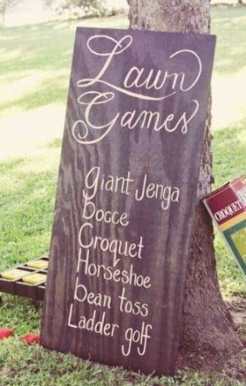 a lawn game sign sitting next to a tree