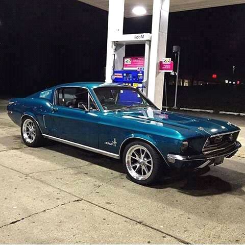 a blue car parked in front of a gas station