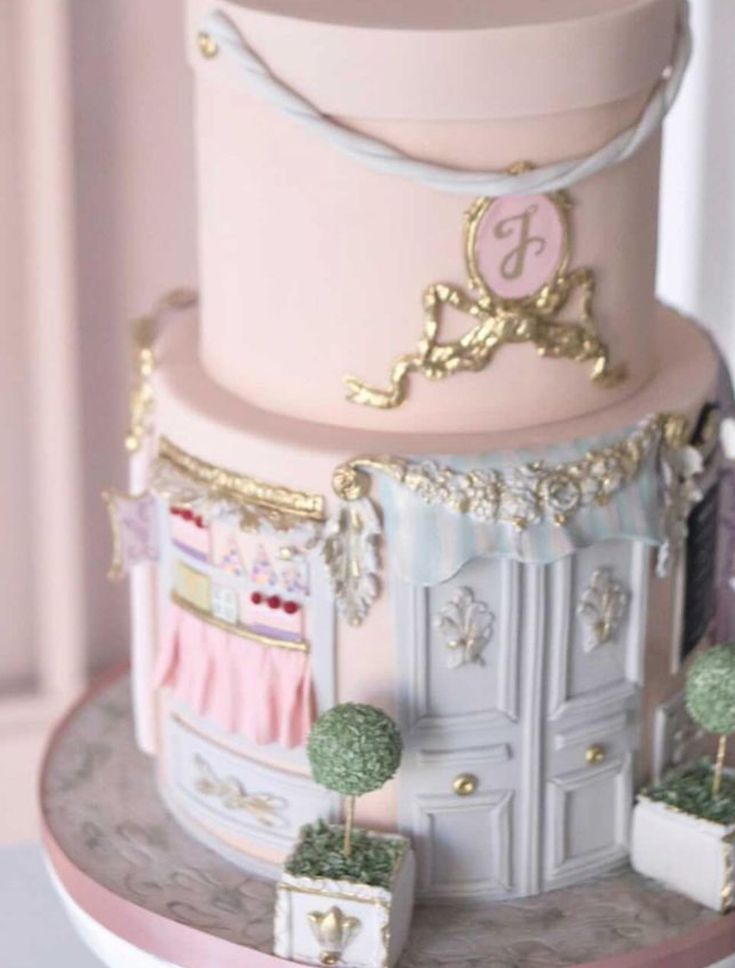 a three tiered cake with pink and gold decorations