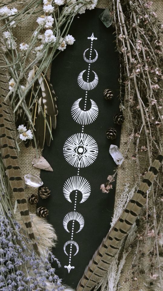 an arrangement of different types of flowers and plants on a black surface with white designs