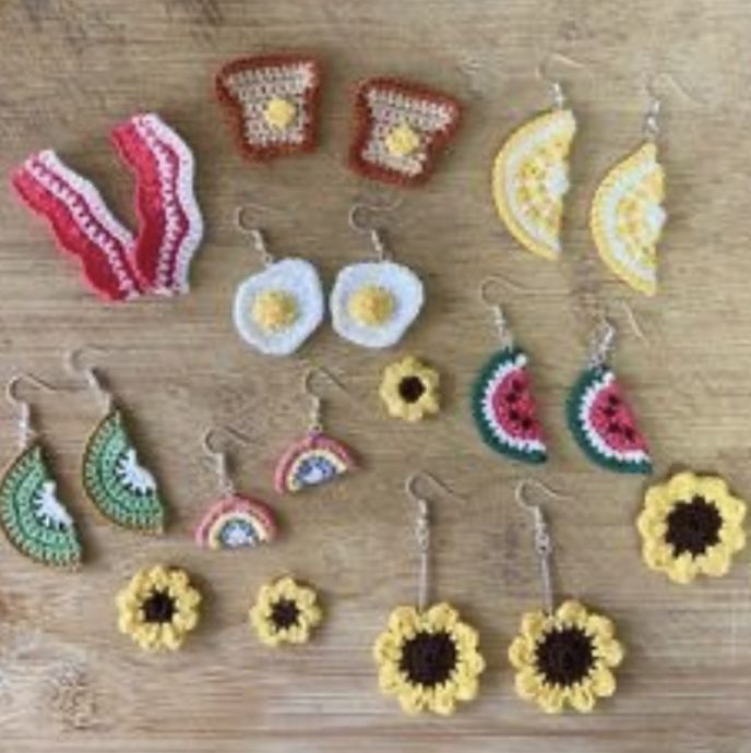 crocheted earrings and earring sets on a wooden table with watermelon