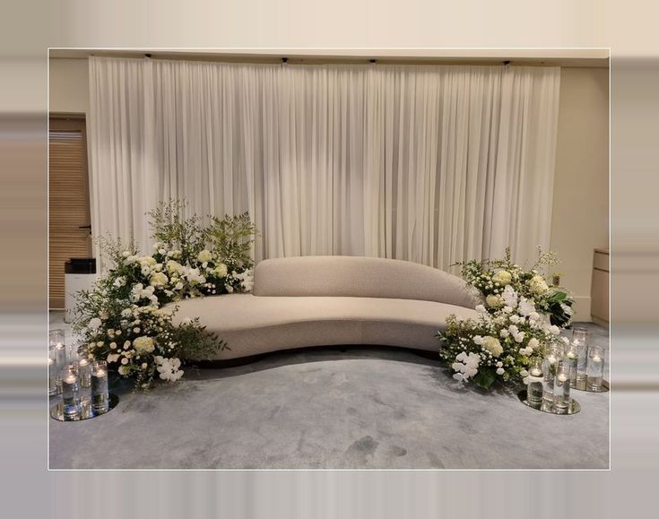 a curved couch surrounded by candles and flowers