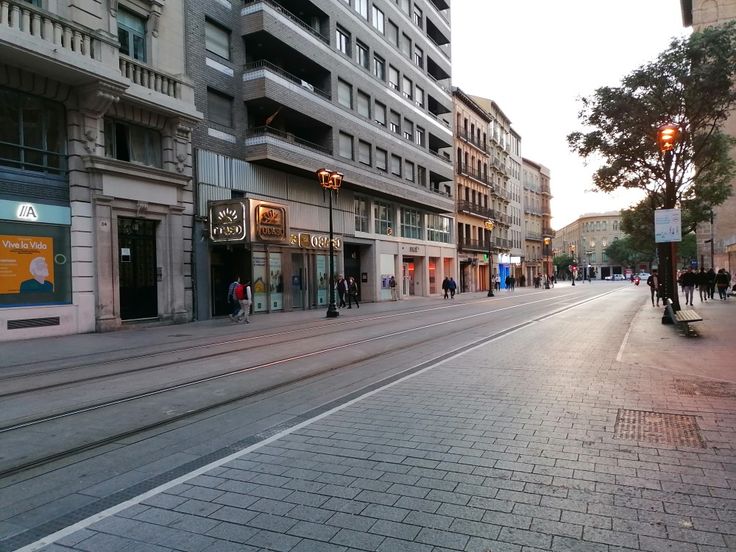 people are walking down the street in front of some buildings