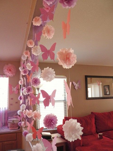 some paper flowers hanging from the ceiling in a living room