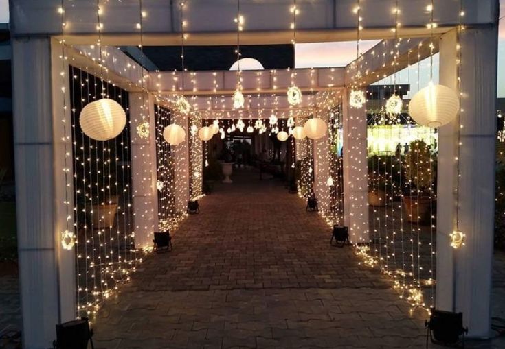 an outdoor gazebo decorated with lights and lanterns