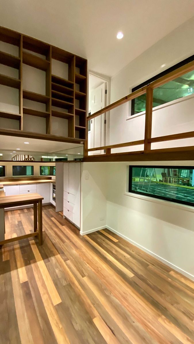 an empty kitchen with wooden floors and white cabinets