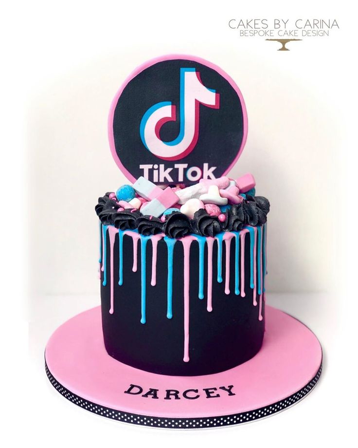 a black and pink cake with icing on it that says tiktok dancey