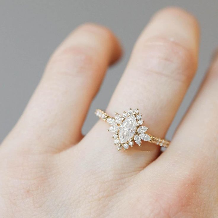 a woman's hand with a diamond ring on top of her finger, showing the center stone