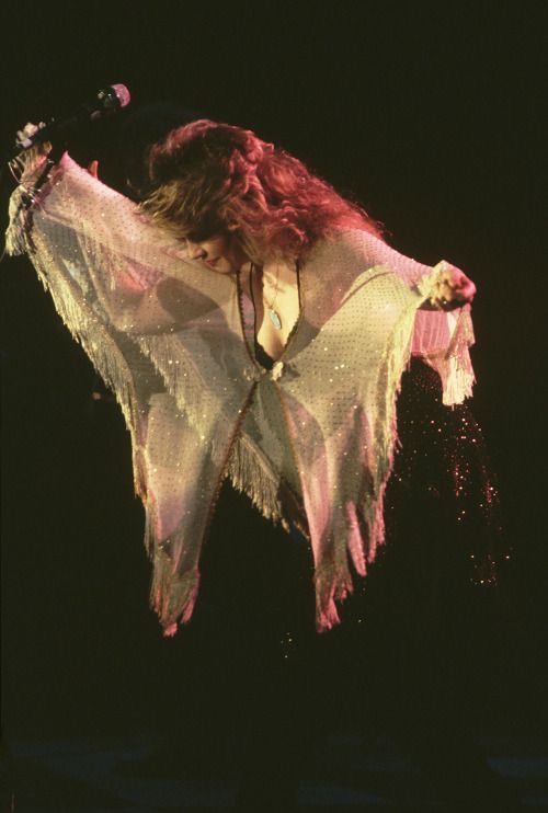 a woman with long hair is performing on stage