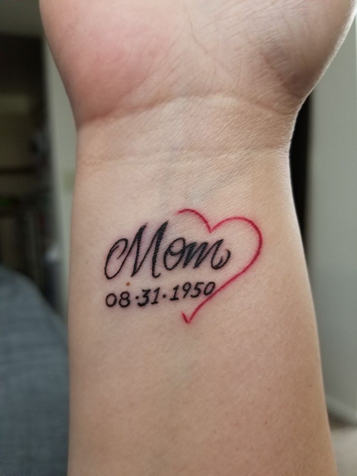 a woman's wrist tattoo with the word mom written in black ink on it