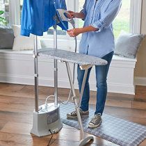 a woman ironing clothes on an ironing board