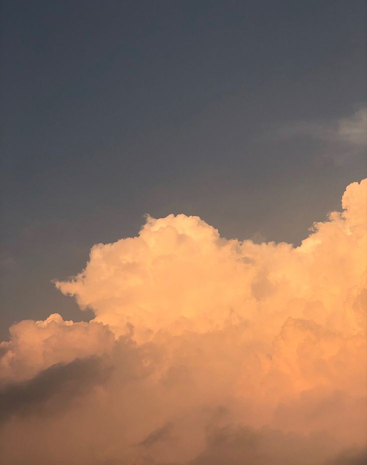 the airplane is flying high in the sky with some clouds behind it and another plane on the ground below