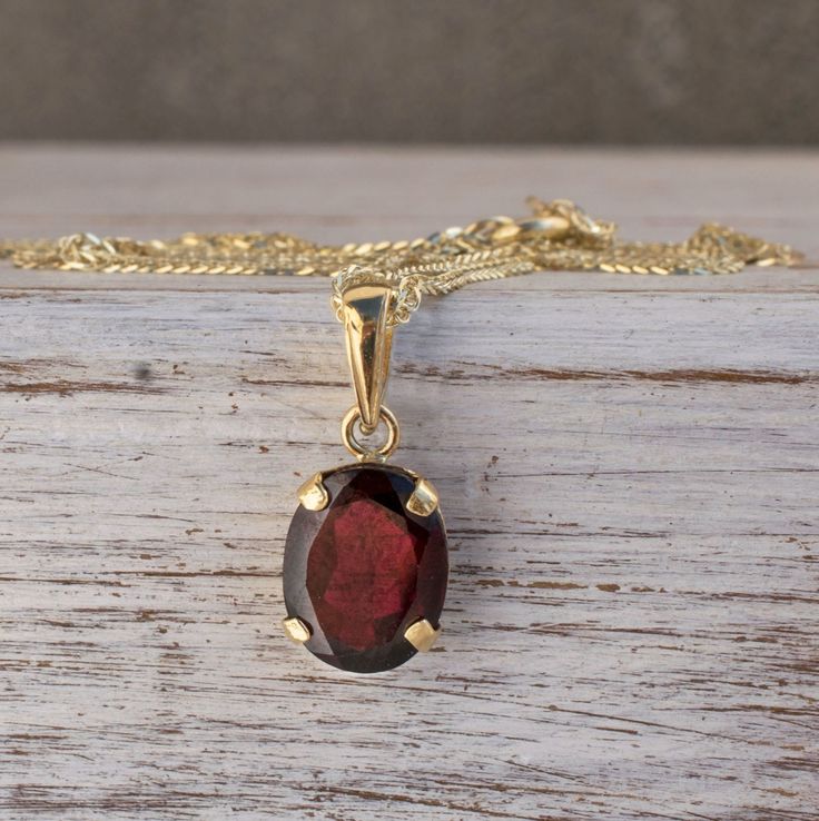 "Unique Red Garnet Pendant Necklace, made of 14K Solid Yellow Gold, Oval Shaped, Fine Jewelry for Women, Handmade By AditaGold. This beautiful handmade short necklace is made of 14K yellow gold and gorgeous oval shaped red garnet gemstone. This handmade pendant necklace is carefully handcrafted at my workshop in Israel. Garnet is January's birthstone, and this solid gold and garnet necklace will be perfect for any occasion. It is classic and elegant and will add a beautiful sparkle to a day or e Classic Red 14k Gold Necklace, Gold Oval Garnet Necklaces, Yellow Gold Oval Garnet Necklace, Oval Garnet Gold Necklace, Yellow Gold Garnet Necklaces With Oval Shape, Classic Garnet Gemstone Necklace, Red Oval Hallmarked Necklace, Classic Red Hallmarked Necklace, Classic Garnet Birthstone Necklace