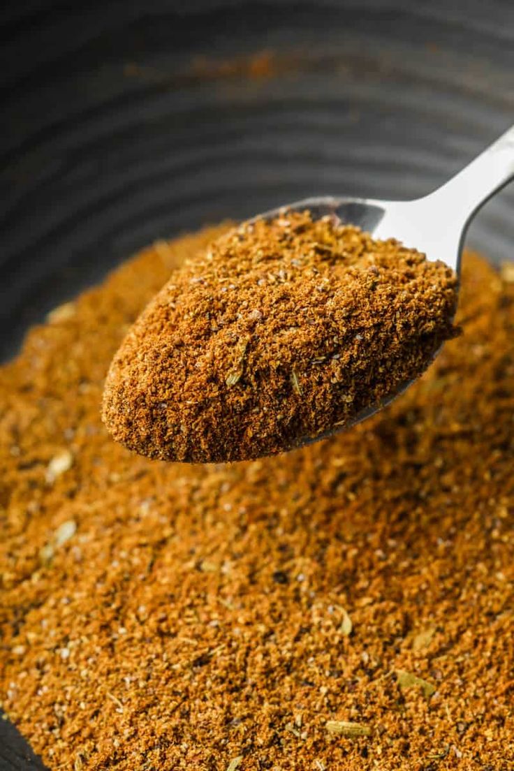 a spoon full of ground spices in a bowl