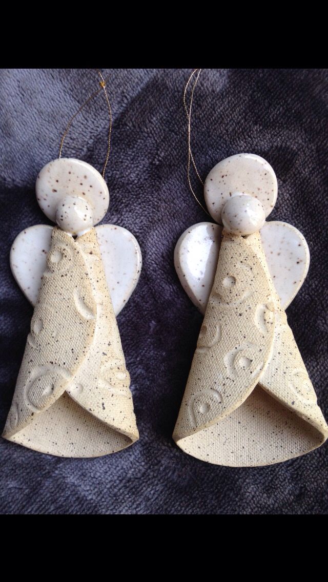 two ceramic angel ornaments hanging from strings