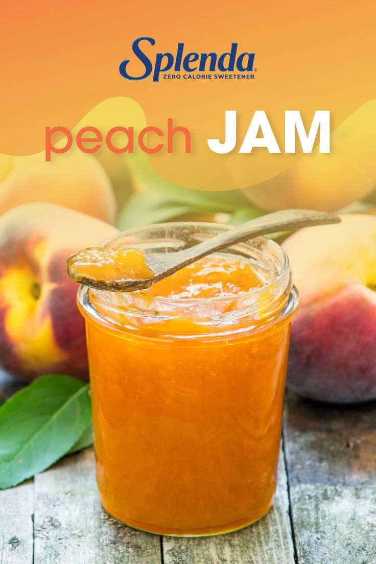 a jar filled with peach jam sitting on top of a wooden table