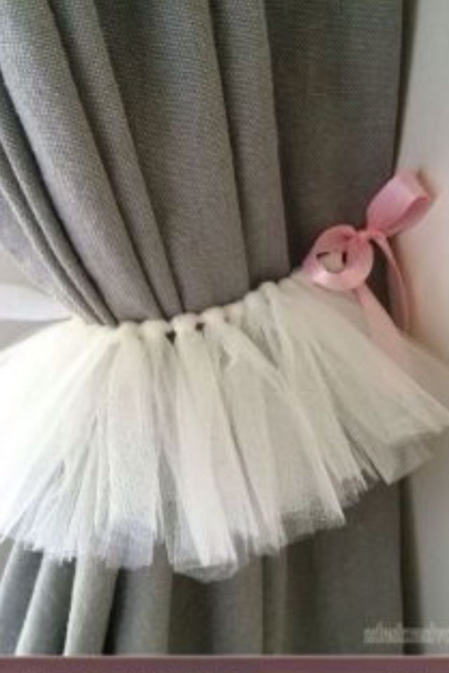 a curtain with a pink bow on it and white tulle hanging from the side