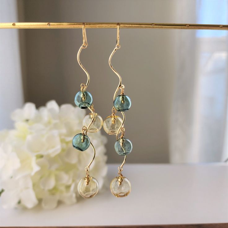 Our brown and deep green bubble drop earring is made with hand blown glass bubbles and high quality 14k gold plated hook which is good for delicate ears. 💖 Hypoallergenic🎀 Cute & Dainty🎁 Gift ready🌹 Handmade with love Gold Glass Earrings With Dangling Beads, Gold Wire Wrapped Glass Earrings, Gold Teardrop Glass Earrings, Bubbles Wedding, Bubble Earrings, Long Earring, Green Bubble, Glass Bubble, Earring Dangle