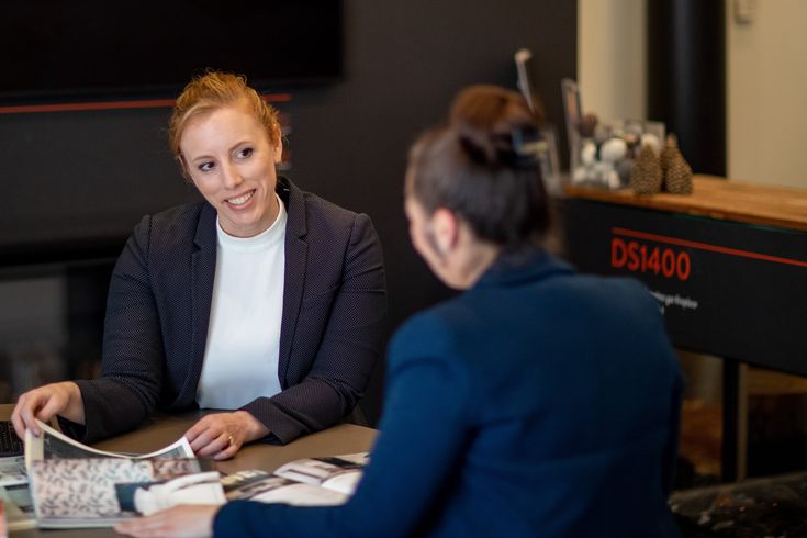 two women sitting at a table talking to each other