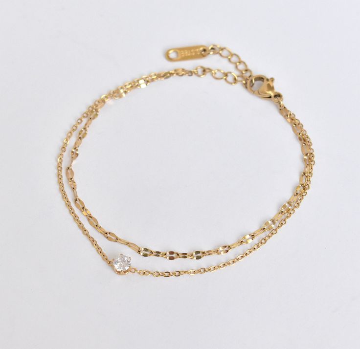 ADJUSTABLE 18K GOLD DAINTY DUO SOLITAIRE BRACELET Materials: stainless steel, 18K gold plated, cubic zirconia Measurement: 6.5" length + 1.5" extension = 8" total length Closure: Lobster clasp Additional Info: Hypoallergenic High Polish Eco-friendly: We use sustainable metals and recycled gold Tarnish resistant and waterproof: No worries about color fading here. With proper care, this piece will last for years! See our care section for more details. 1-year warranty All of our gold jewelry is pla Solitaire Bracelet, Bracelet Materials, Etsy Bridesmaid Gifts, Waterproof Jewelry, Recycled Gold, Gold Plated Jewelry, Chain Link Bracelet, Chain Link, Bridesmaid Gifts