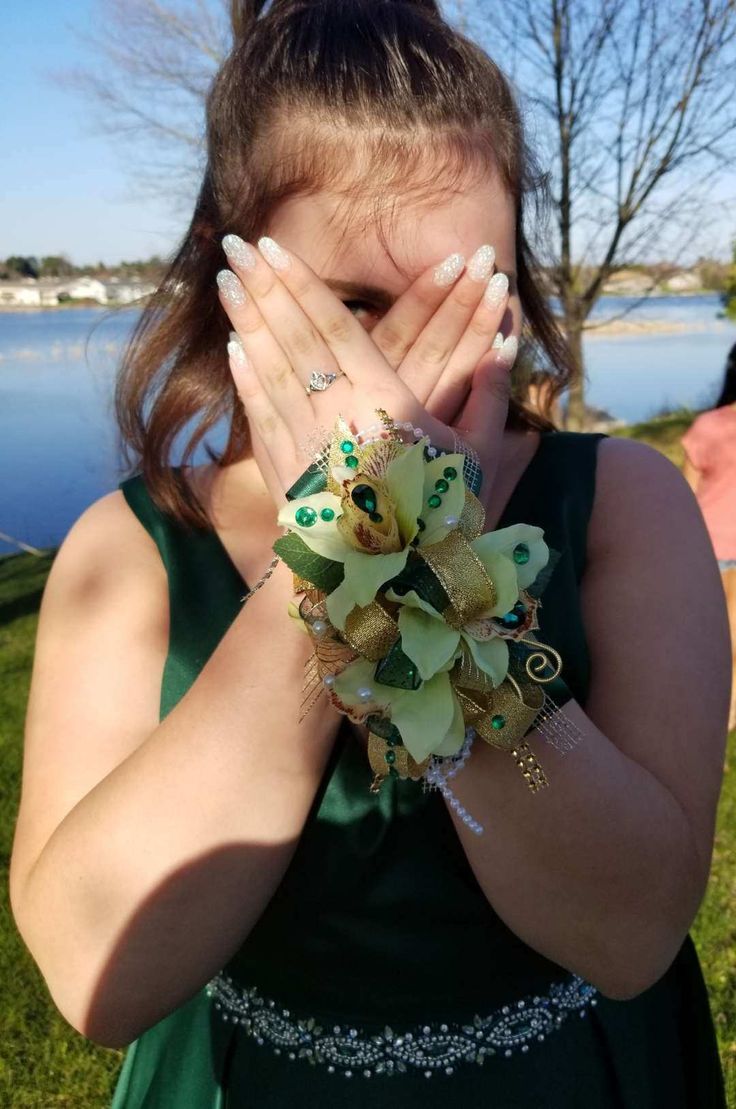 a woman in a green dress holding her hands to her face and covering her eyes