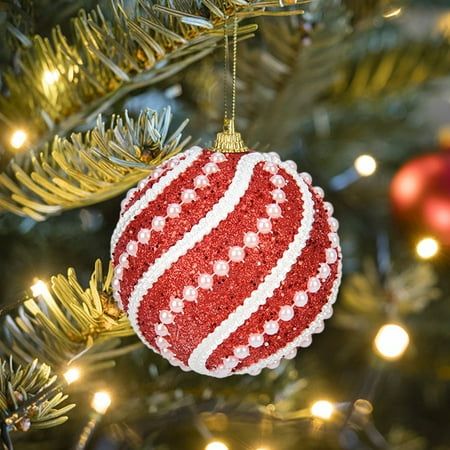 a red and white ornament hanging from a christmas tree