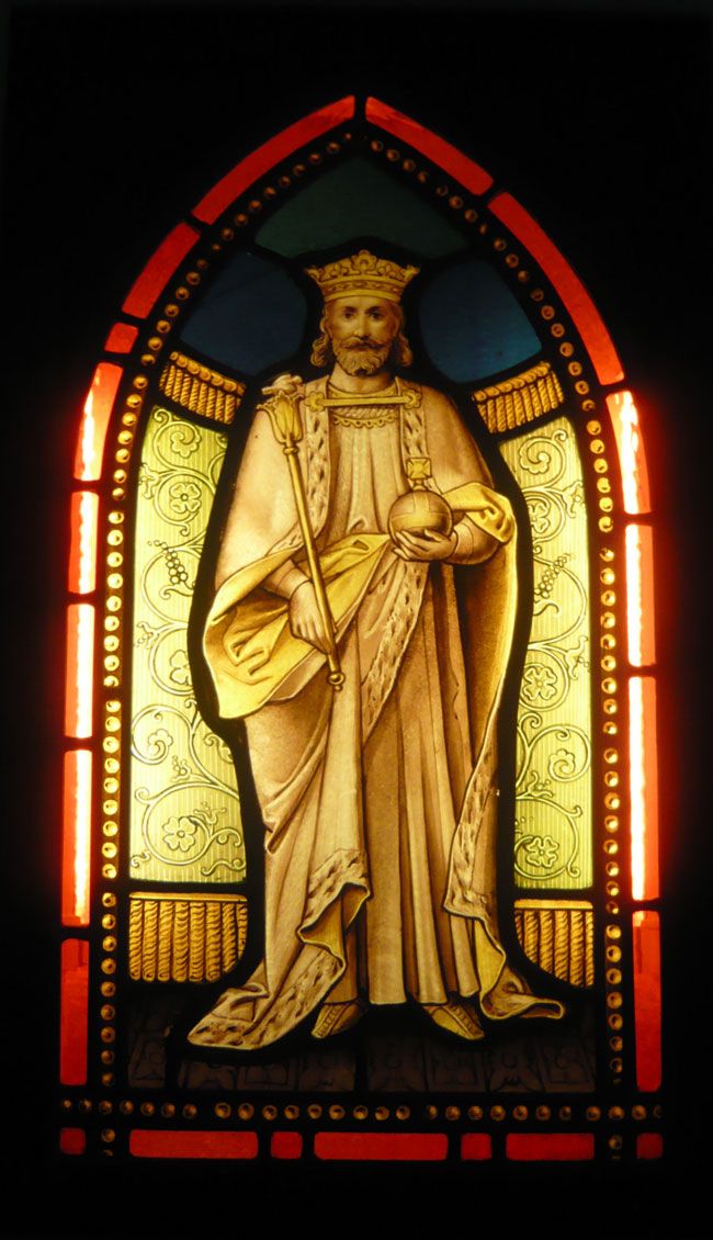 a stained glass window with a statue of jesus