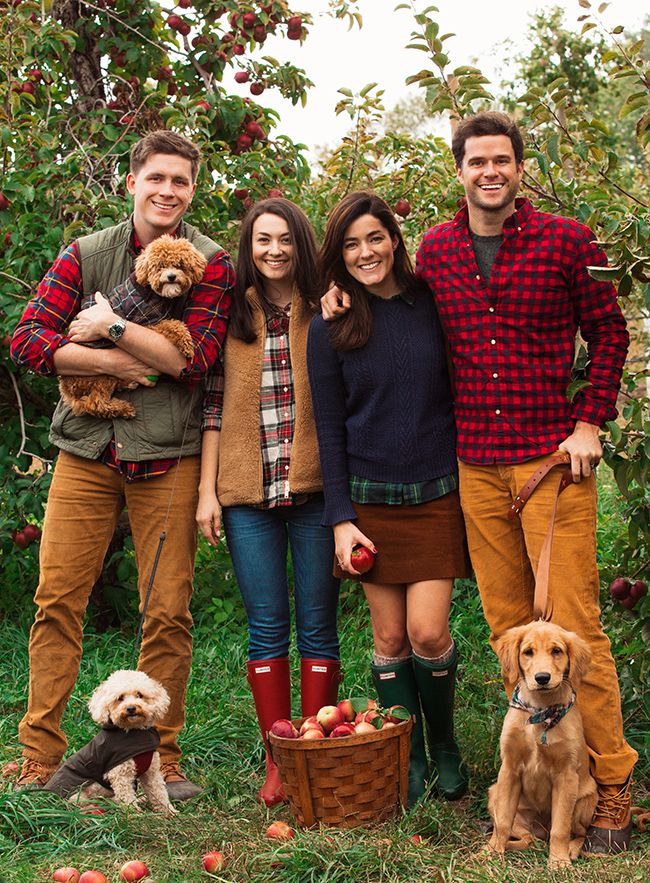 an image of people posing for a photo with their dogs and apples in the background