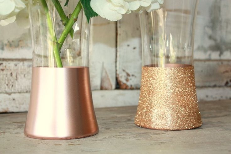 two vases with flowers in them sitting on a table