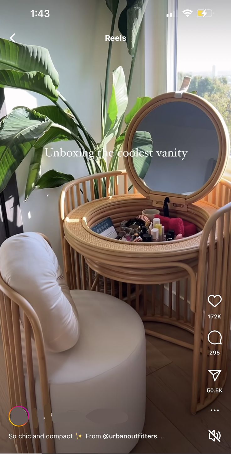 a round table with a mirror on it next to a chair and potted plant