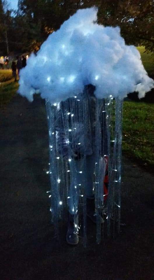 a man standing in front of a cloud with lights on it's head and arms