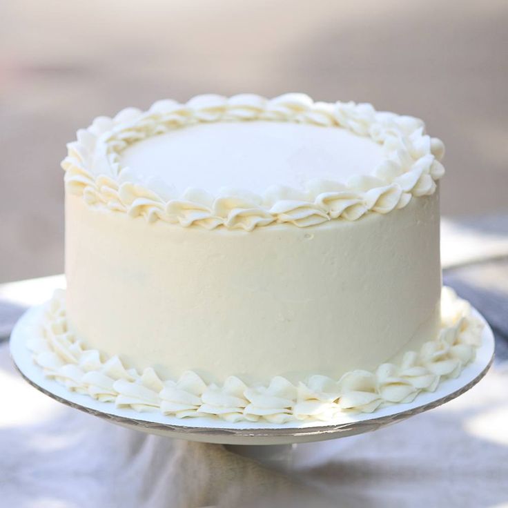 a white frosted cake sitting on top of a table