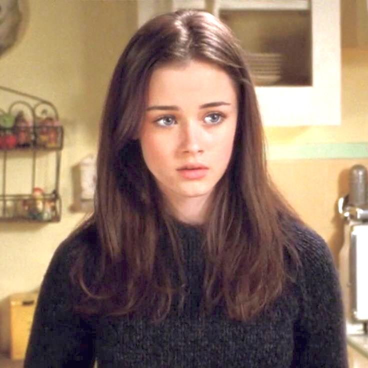 a young woman standing in a kitchen looking at the camera