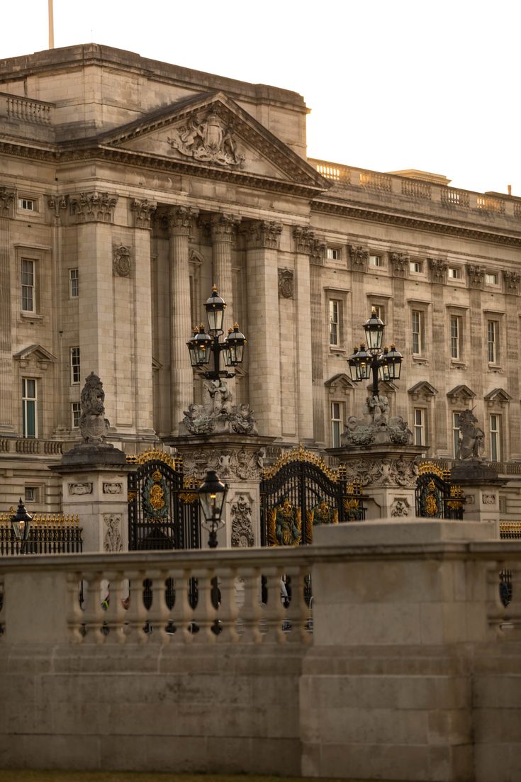 an old building with ornate ironwork and lamps on the top balcony, in front of it