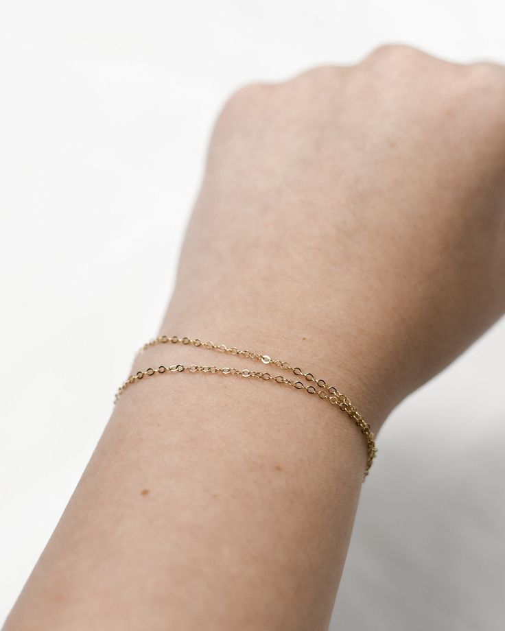 "𝗘𝗮𝘀𝘆 𝗧𝗼 𝗦𝘁𝘆𝗹𝗲, 𝗠𝗮𝗱𝗲 𝗧𝗼 𝗟𝗮𝘀𝘁 Our double wrapped chain is a classic and minimalist addition to your everyday bracelet stack! 𝗠𝗮𝘁𝗲𝗿𝗶𝗮𝗹𝘀 𝗪𝗲 𝗨𝘀𝗲 This bracelet is made entirely with sturdy 14k gold filled or sterling silver pieces. It is safe to wear in the shower, but we recommend avoiding prolonged exposure to chemicals like chlorine to keep your bracelet like new! 𝗟𝗲𝗻𝗴𝘁𝗵 𝗢𝗽𝘁𝗶𝗼𝗻𝘀    This bracelet is available in 5\", 6\", 7\", and 8\" sizes. Each comes with a 1\" extender chain. 𝗠𝗼𝗿𝗲 𝗗𝗲𝘁𝗮𝗶𝗹𝘀 -Chain measures 1.3mm -Spring ring clasp 𝗘𝘅𝘁𝗿𝗮𝘀 𝗮𝗻𝗱 𝗔𝗱𝗱 𝗢𝗻𝘀 Gift Box This gift box has a velour interior and features a sliding drawer style; it is a perfect place to keep your piece when it's not being worn! https://www.etsy.com/li Dainty Double Chain Everyday Jewelry, Minimalist 14k Gold Filled Jubilee Bracelet, Classic Gold Bracelets For Friendship, Dainty Yellow Gold Bracelet For Everyday, Dainty Bracelets For Layering, Dainty Delicate Chain Bracelets For Layering, Minimalist 14k Gold Double Chain Jewelry, Minimalist Yellow Gold Jewelry With Double Chain, Minimalist Yellow Gold Jubilee Charm Bracelet