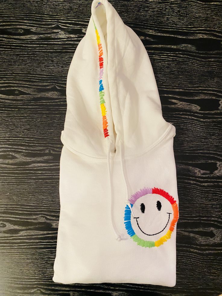 Hand embroidered rainbow smiley face hoodie!! Trendy Embroidered Hooded Hoodie, Rainbow Casual Winter Hoodie, Casual Winter Rainbow Hoodie, Fun Cotton Hoodie, Fun Cotton Hooded Hoodie, Rainbow Cotton Hooded Hoodie, Rainbow Cotton Hoodie, Casual Rainbow Hoodie For Streetwear, Fun Hoodie Sweatshirt With Drawstring Hood