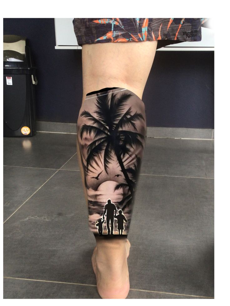 a man's leg with an image of two people and a palm tree on it