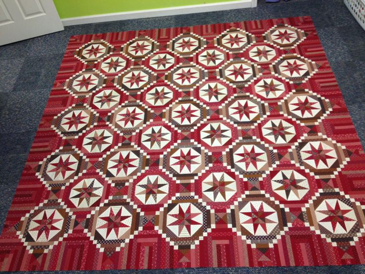 a large red and white quilt on the floor