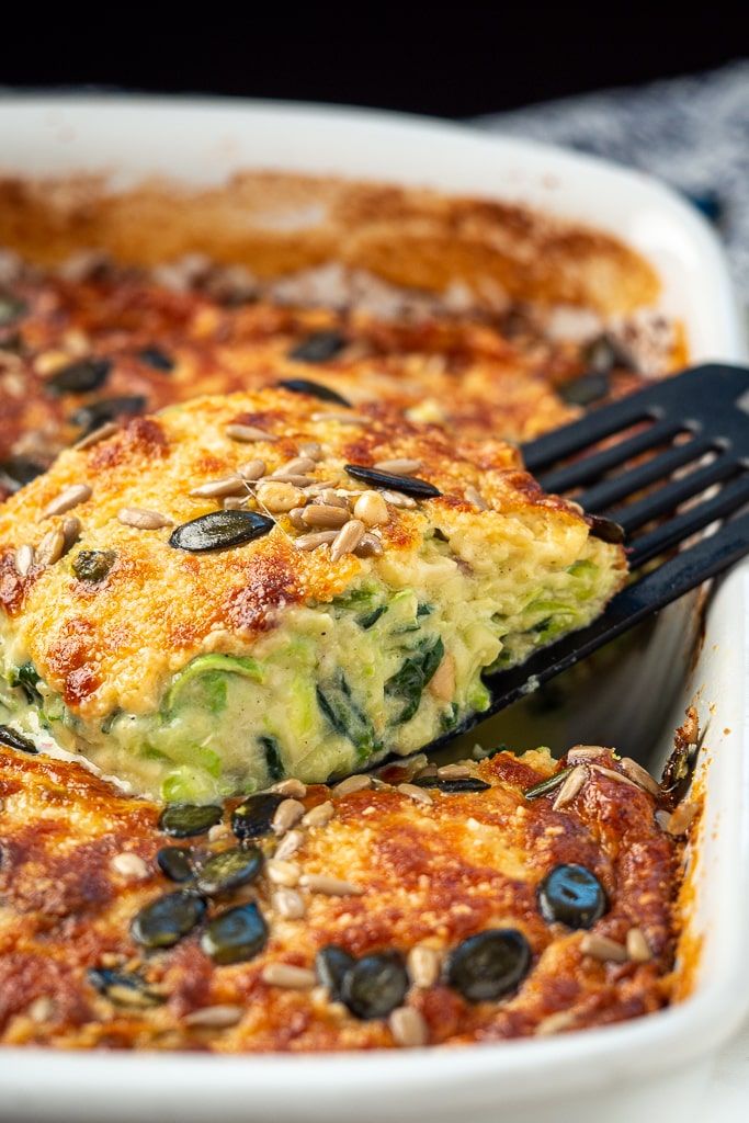 a close up of a casserole dish with broccoli and olives