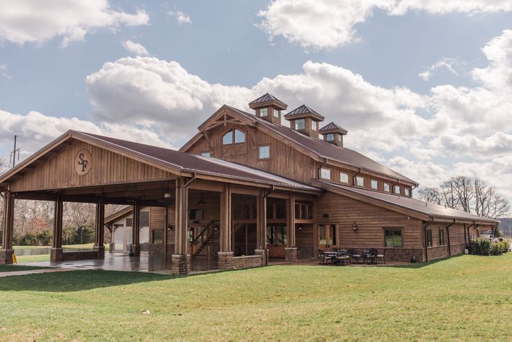 a large wooden building sitting on top of a lush green field